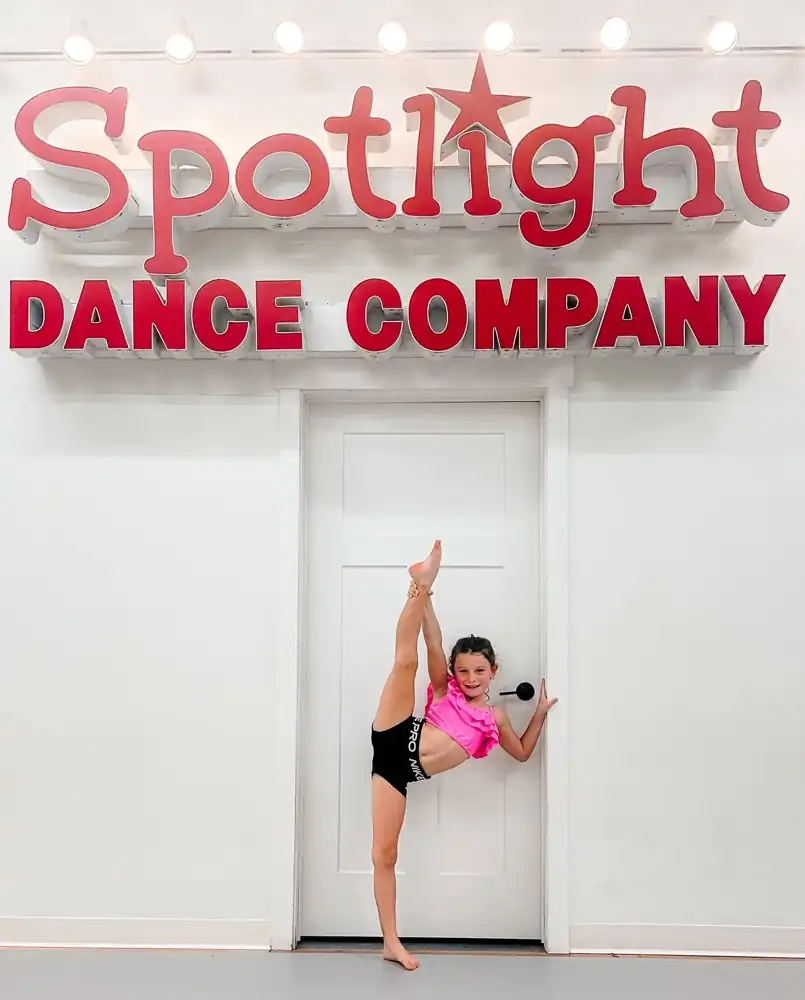 Young dancer practicing an acrobatic pose during a dance class