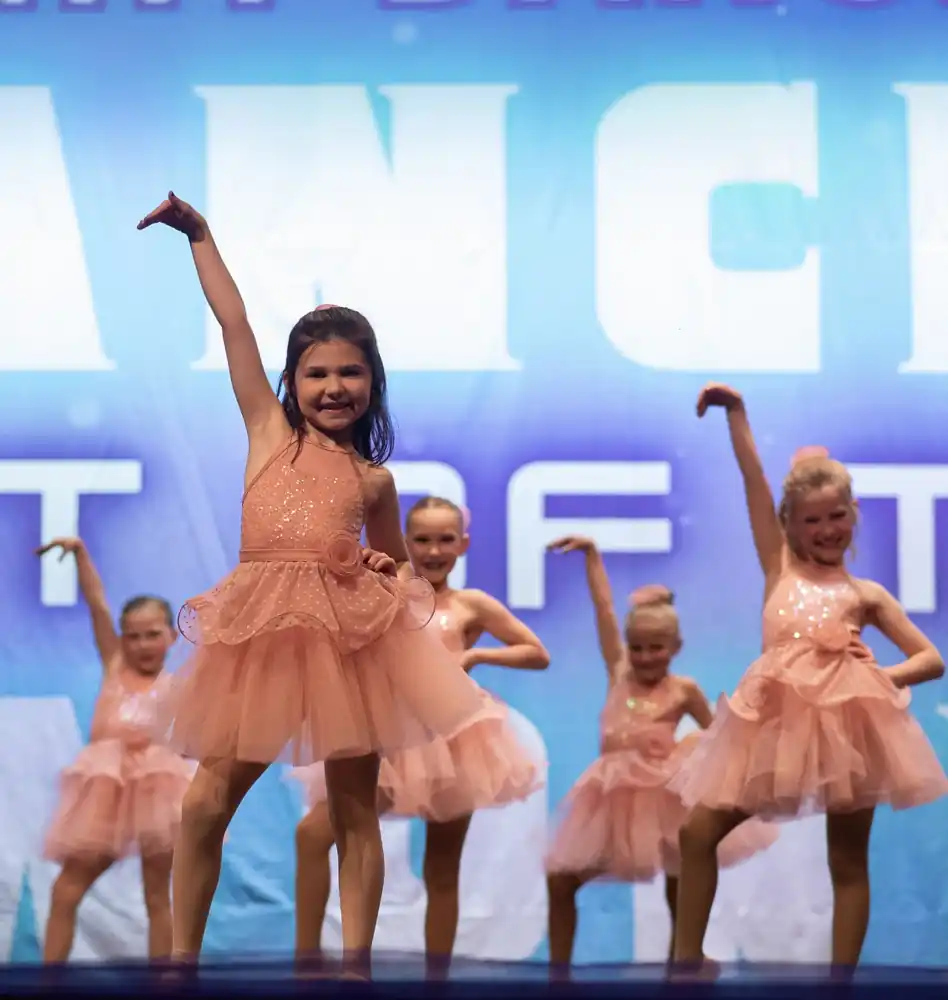 Preschool and kindergarten dancers performing together in colorful costumes